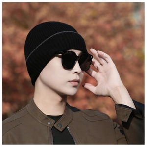 Detail of ribbed knit texture on black winter beanie with gray stripe for men