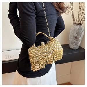 Chic gold evening clutch bag with sparkling rhinestones and tassels worn by a model