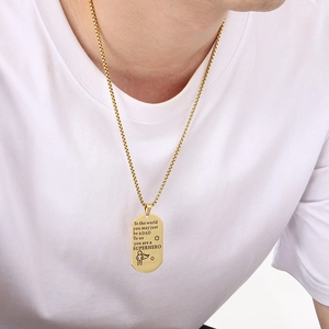 Detail of gold dad necklace showing superhero engraving and polished box chain finish