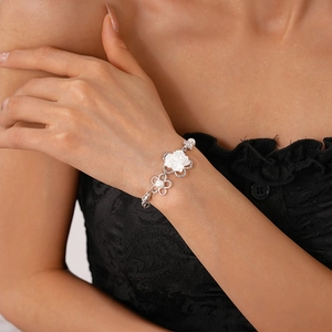 Dettaglio della collana di perle con fiori sul collo e raffinati fiori in argento lucido