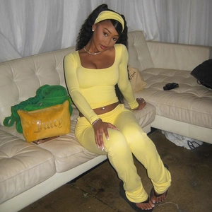 Detail of yellow velvet lounge set featuring square neck top and flared pants on a sofa