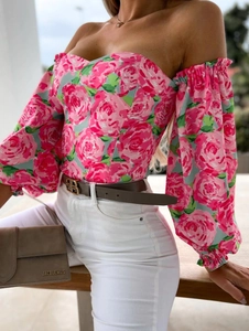 Detail of off-shoulder floral blouse with romantic pink rose patterns and smocked cuffs
