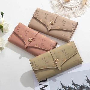 Detailed view of three long wallets in pink, khaki, and green with leaf metal buckle
