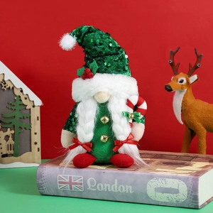 Christmas gnome doll with green sequin hat and candy cane on a festive red background