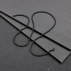 Detail of a black woven stainless steel chain necklace with lobster clasp closure