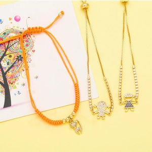 Detailed view of woven orange rope and gold box chain bracelets with zircon charms