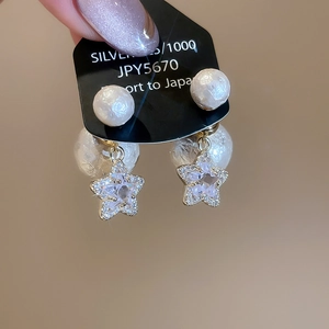 Detailed macro of 925 silver earring featuring star zircon and elegant pearl drop