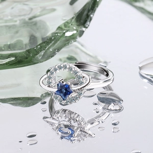 Macro shot of silver planetary ring featuring blue star gem and shimmering crystal ring