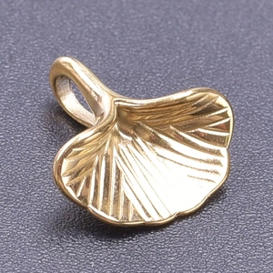 Macro shot of 18k gold plated ginkgo leaf pendant with detailed texture and top ring