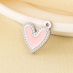 Detailed macro view of heart-shaped stainless steel pendant with pink enamel and silver beads