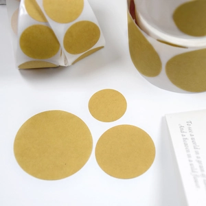 Macro shot of circular brown kraft paper adhesive labels in various sizes on table