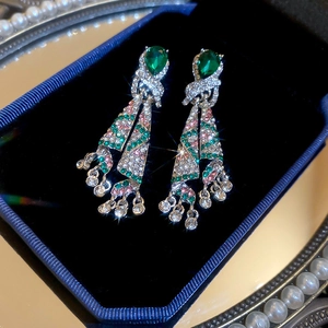 Vue détaillée des boucles d'oreilles vintage avec pierre verte en boîte bleue