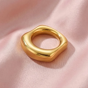 Close-up of 18k gold plated irregular square ring on elegant pink silk fabric