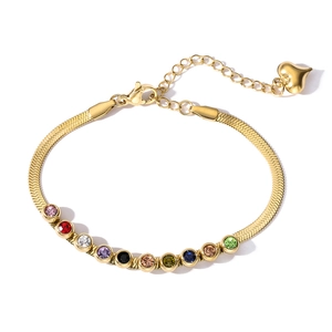 Detail of gold snake chain bracelet featuring multi-colored gemstones and a heart charm