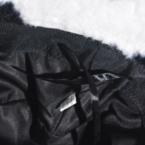 Detailed view of black polyester lining and adjustable satin drawstring inside the cow print hat