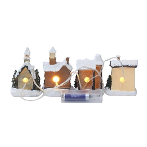 Detailed view of four lighted Christmas miniature houses with warm LED bulbs and snow coating