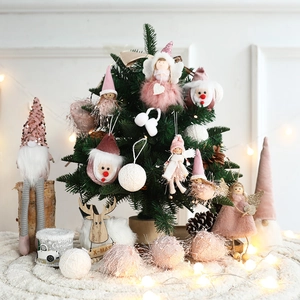 Pink and white plush Christmas ornaments set with gnomes and angels in cozy warm lighting