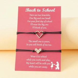 Detail of Back to School bracelets with silver heart charms on a pink display card