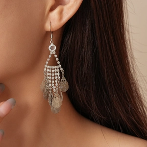 Close-up of sparkling hollow leaf fringe earrings with silver rhinestones on model