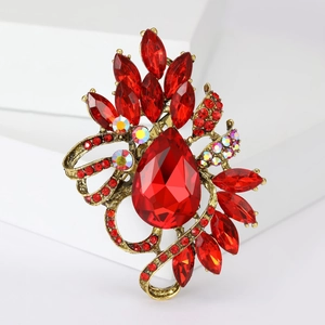 Elegant vintage gold brooch with large red teardrop crystal and surrounding rhinestones