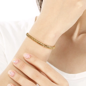 Élégant bracelet chaîne épi plaqué or 18 carats pour femme sur poignet avec fini doré