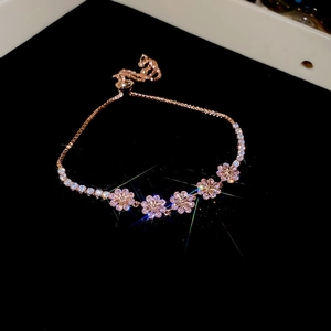 Detail of rose gold flower bracelet with pink zircon stones and adjustable pull chain