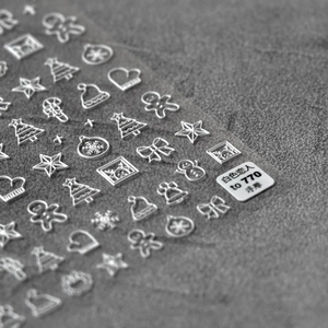 Macro view of 5D white embossed Christmas nail stickers featuring snowflakes and gingerbread
