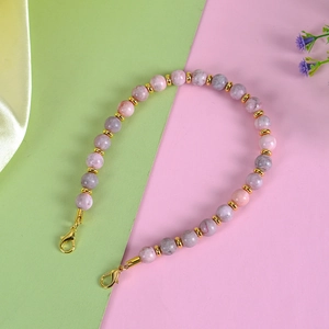 Close-up of pink and lilac natural stone beads with gold spacers and lobster clasps