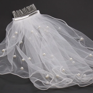 Detailed view of white bridal veil with scattered pearls and integrated metal hair comb