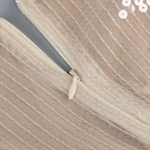 Macro shot of invisible zipper closure on mesh evening dress with white sequins
