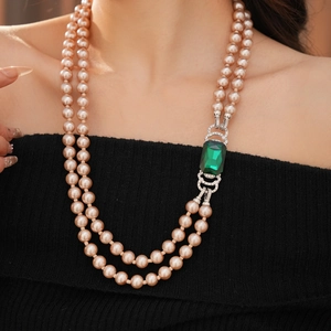 Dettaglio collana vintage a due strati di perle champagne con pendente smeraldo su modella