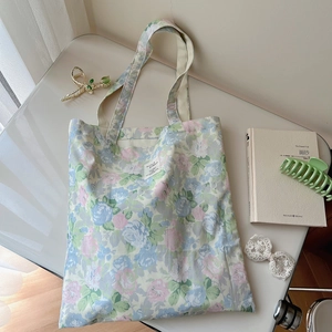 Detail shot of vintage floral cotton tote bag with pastel flower prints and woven label