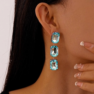 Close-up of model wearing three-tiered sea blue crystal rectangular fringe drop earrings