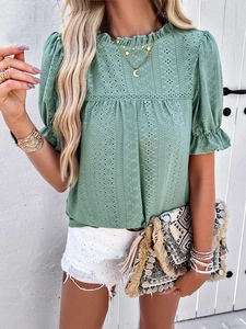 Detail of green hollow embroidery top with puff sleeves and ruffled neckline