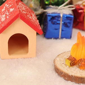 Miniature dollhouse Christmas cabin with tiny campfire and artificial snow decor