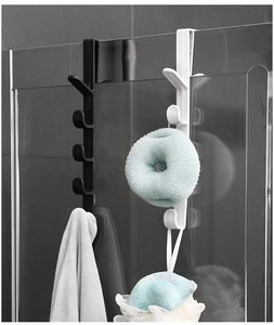 Vertical over-the-door hooks holding towels and loofah on a glass shower door