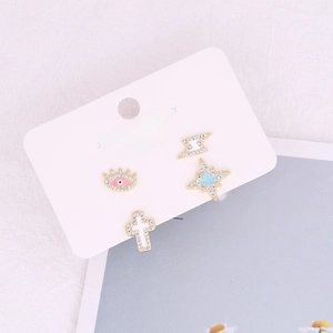 Detailed close-up of zircon earrings set with eye and lightning shapes on 925 silver posts