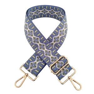 Detail of colorful geometric woven shoulder strap with gold metal lobster clasps
