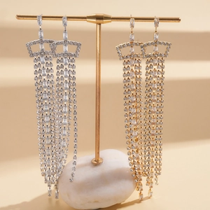 Luxurious long tassel drop earrings with sparkling cubic zirconia on a gold display stand