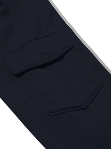 Macro shot of cargo pants pocket with button detail and premium woven fabric texture