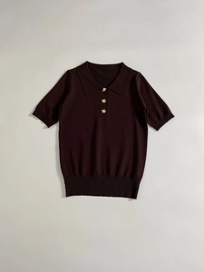 Detailed close-up of dark brown knit polo shirt featuring ornate gold flower buttons