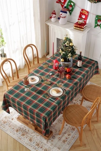 Close-up of a festive red and green plaid tablecloth set on a Christmas dining table