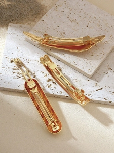 Three gold minimalist irregular spring clips in bar, rectangle, and wave shapes