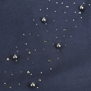 Macro detail of navy knit hat featuring silver metallic beads and sparkling rhinestones