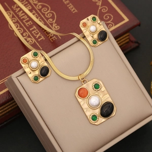Golden jewelry set with textured pendant, colorful stones, and pearl on snake chain necklace