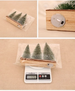 Detail view showing battery compartment on wood base and total weight of 3 mini Christmas trees