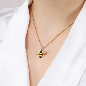 Elegant gold bee pendant necklace with yellow and black enamel on a delicate cross chain