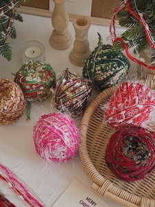 Christmas plush pompom balls with gold thread in rustic basket and holiday setting