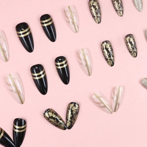 Luxury dark gold fluid style stiletto press-on nails in black and pink marble finish