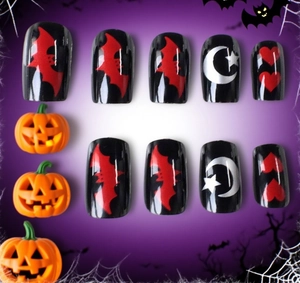 Detailed view of Halloween press-on nails featuring black bats, moons and stars motifs